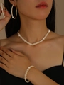 Sparkling gold-toned jewelry set with necklace, bracelet, and hoop earrings on model - Gold Necklace Earrings Bracelet