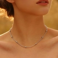 Close-up of minimalist silver beaded snake chain necklace on model neck in warm sunlight - Round Bead Necklace (Silver) 45+5