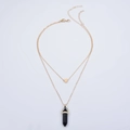 Detail of double-layer gold necklace featuring a heart charm and black hexagonal prism pendant - Blue Goldstone