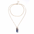Detailed macro of a double-layered gold chain with a blue hexagonal crystal pendant - Blue Spot Jasper