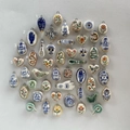 Detail showing various hand-painted ceramic charms with gold plating and metal loops - Painted Ceramic Oval Daisy Pendant / Pendant Only (No Chain)