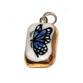Détail d'un pendentif rectangulaire en or avec motif papillon bleu sur céramique blanche - Papillon Carré