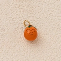 Detail view of a bright orange fruit pendant with a green leaf and smiling face - Orange Persimmon Pendant