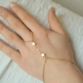 Boho-Fingerarmband in Gold mit weißen Sternanhängern an der Hand eines Models - Pentagramm-Anhänger-Stil (LS004-18)