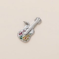 Detailed macro view of a silver guitar pendant with colorful enamel flower and butterfly - Guitar