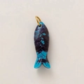 Dettaglio ravvicinato di un ciondolo a forma di pesce in resina marmorizzata viola e oro - Pesce Blu Scuro / Blu scuro