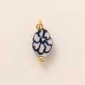 Detalle macro del colgante de cerámica floral azul y blanco con un elegante baño de oro - Colgante de Flor de Cerámica Azul y Blanco
