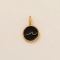 Macro detail of round gold-plated pendant with black enamel and embossed wave pattern - Black Enamel Wave Pendant