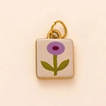 Vista macro del colgante cuadrado dorado con flor morada sobre esmalte blanco - Colgante Blanco con Flor Púrpura
