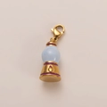 Macro detail of a 18K gold plated lamp pendant with blue sphere and red crystal inlay - Gold Chandelier Charm