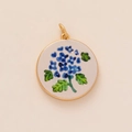 Gold plated circular charm with blue hydrangea floral pattern and matte ivory base - Small Blue Flower Pendant (1)