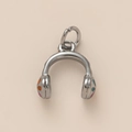 Détail macro d'un pendentif casque argenté avec des points émaillés colorés pour bijoux - Casque audio