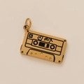 Gros plan du pendentif cassette vintage en or avec détails gravés face A, cœur et texte MIX - Cassette Or