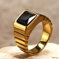Détail macro d'une bague pour homme en titane doré avec pierre noire carrée et texture côtelée - US 6 / Or Strass Noir