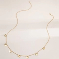 Dettaglio di una catena in oro per la vita con eleganti ciondoli a farfalla su sfondo bianco - Oro