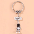 Portachiavi astronauta argento con placca Friends incisa su sfondo arancione pulito - Stella Friends
