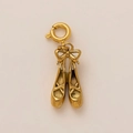 Macro view of golden ballet slipper pendant with delicate bow and spring clasp closure - Dance Shoes Pendant