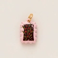 Detail of a black enamel stamp pendant with pink berry motif and gold plated loop - Stamp Style Plant Pendant