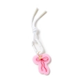 Pink acrylic bow charm pendant with white plastic carabiner and woven cord on white backdrop - Bow