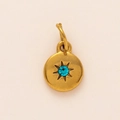 Detailed macro of golden matte round pendant with sunburst star and blue gemstone - March Birthstone Pendant
