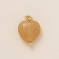 Detail of a heart-shaped amber resin pendant with a polished 18K gold plated metal loop - Yellow Heart
