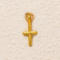 Gros plan détaillé d'un pendentif en croix plaqué or avec une texture de métal martelé - Croix