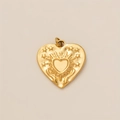 Dettaglio macro di un ciondolo a cuore placcato oro 18K con texture a raggiera e stelle - Pendente a doppio cuore