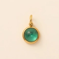 Detail van een 18K vergulde hanger met smaragdgroene steen en concentrische textuur - December Blauwe Topaas Hanger Goud