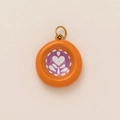 Detailed view of an orange round fruit pendant with a purple heart and gold metal bail - Flower