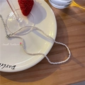 Elegante witte kralenketting met zilveren ketting op een wit keramisch bord - Wit