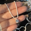 Elegant silver sparkling necklace with a round-cut pendant in a handheld display - Solitaire Necklace / White Zirconia
