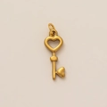 Detail van een matgouden hartvormige sleutelhanger met een elegant opengewerkt ontwerp - Hartsleutel Hanger