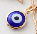 Macro shot of 14k gold-plated evil eye pendant with blue enamel and metallic link detail - Blue Evil Eye