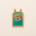 Detailed close-up of a gold tarot pendant featuring a green evil eye and enamel inlay - Blue Green Evil Eye