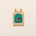 Detailed close-up of a gold tarot pendant with a colorful hummingbird enamel design - Magpie