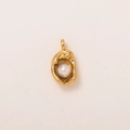 Detailed shot of a round white pearl pendant wrapped in textured 18k gold-plated metal - Pearl Shell Pendant