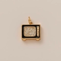Macro shot of retro TV pendant with gold plating, black enamel, and sparkling glitter - Television Style