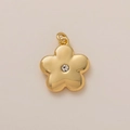 Vue détaillée du pendentif fleur doré orné d'une pierre de zircon étincelante au centre - Fleur