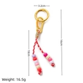 Handmade woven keychain with colorful beads and red-white cord in a golden finish - Pink Cord Beaded Keychain