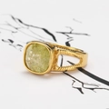 Gros plan sur une bague rétro dorée à double couche avec une pierre naturelle vert clair - Or Pierre Jaune Clair