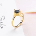 Macro di un anello dorato con quattro punte e incastonatura con pietra nera - US 6 / Oro Nero