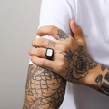Close-up of matte black signet ring with white rectangular shell inlay on tattooed hand - Black White Shell