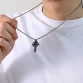 Detalle de un colgante de cruz de plata vintage con piedra azul usado por un modelo - Color Dorado Strass Azul Colgante Solo (Sin Cadena)