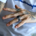 Dettaglio anello punk da uomo in acciaio con incisioni vintage e pietra di agata nera - Agata nera color acciaio