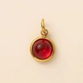 Detailopname van een 18K vergulde ronde hanger met een levendige rode cabochon steen - Juli Robijn Hanger Goud