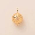 Macro shot of gold sphere pendant featuring a sparkling starburst design and zircon setting - North Star Charm Only