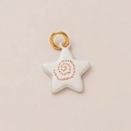 Detail view of gold-plated star pendant with white enamel and orange spiral pattern - Dotted Spiral Pattern Pendant