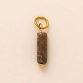 Macro detail of vintage brown stone pendant with white spots and gold rings - Ice Cream Style