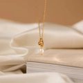 Élégant collier en acier inoxydable doré avec nœud à double anneau et pendentif perle - Collier Torsadé Doré