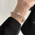 Detail of pink heart accents on silver-toned thorn chain bracelet worn on wrist - Bracelet